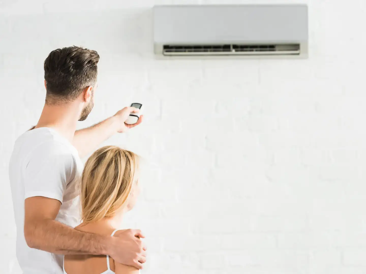 Couple profitant de la fraîcheur d'une pièce climatisée dans sa maison