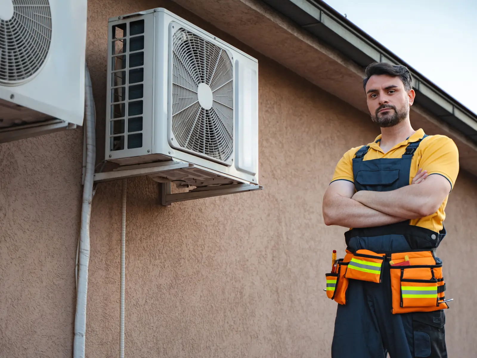 Dépanneur en intervention devant le groupe extérieur d'une climatisation