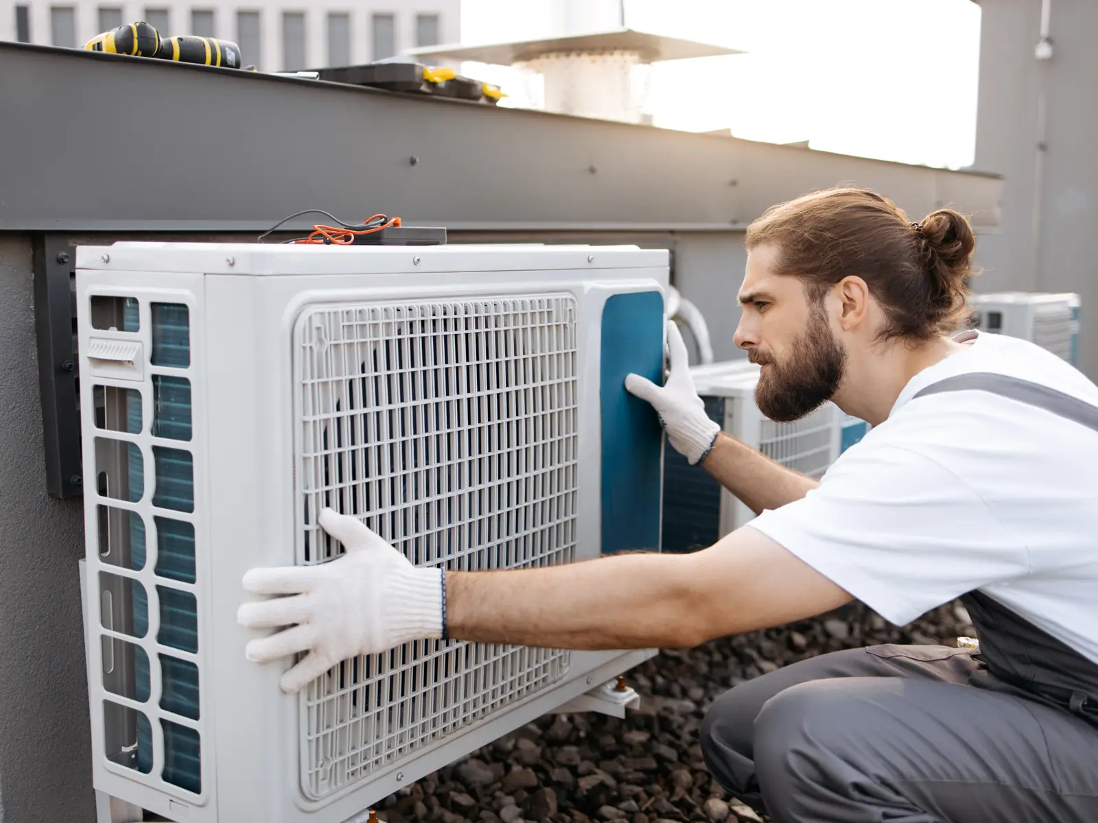 Technicien mettant en place le groupe extérieur d'une climatisation monosplit