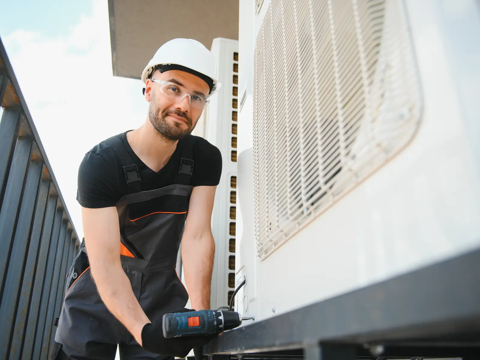 Technicien en train de réparer une unité de climatisation démontée