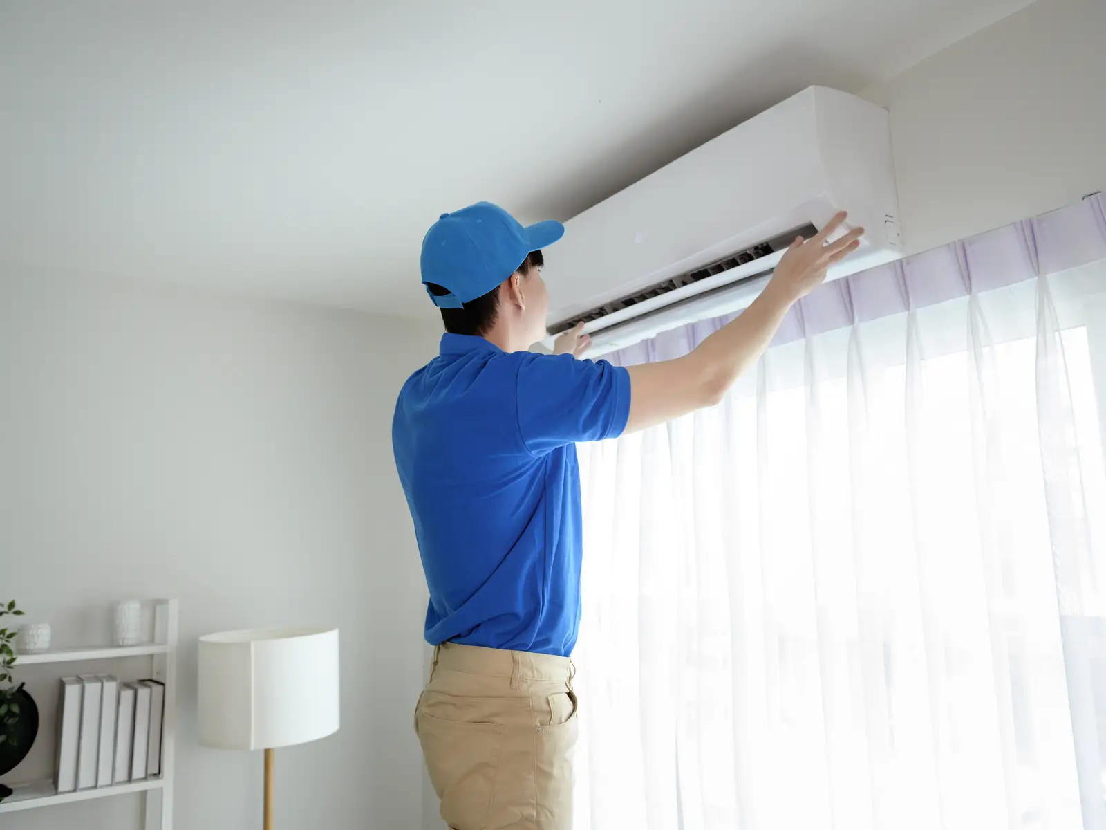 Technicien vérifiant une unité murale de climatisation qui refuse de se mettre en route